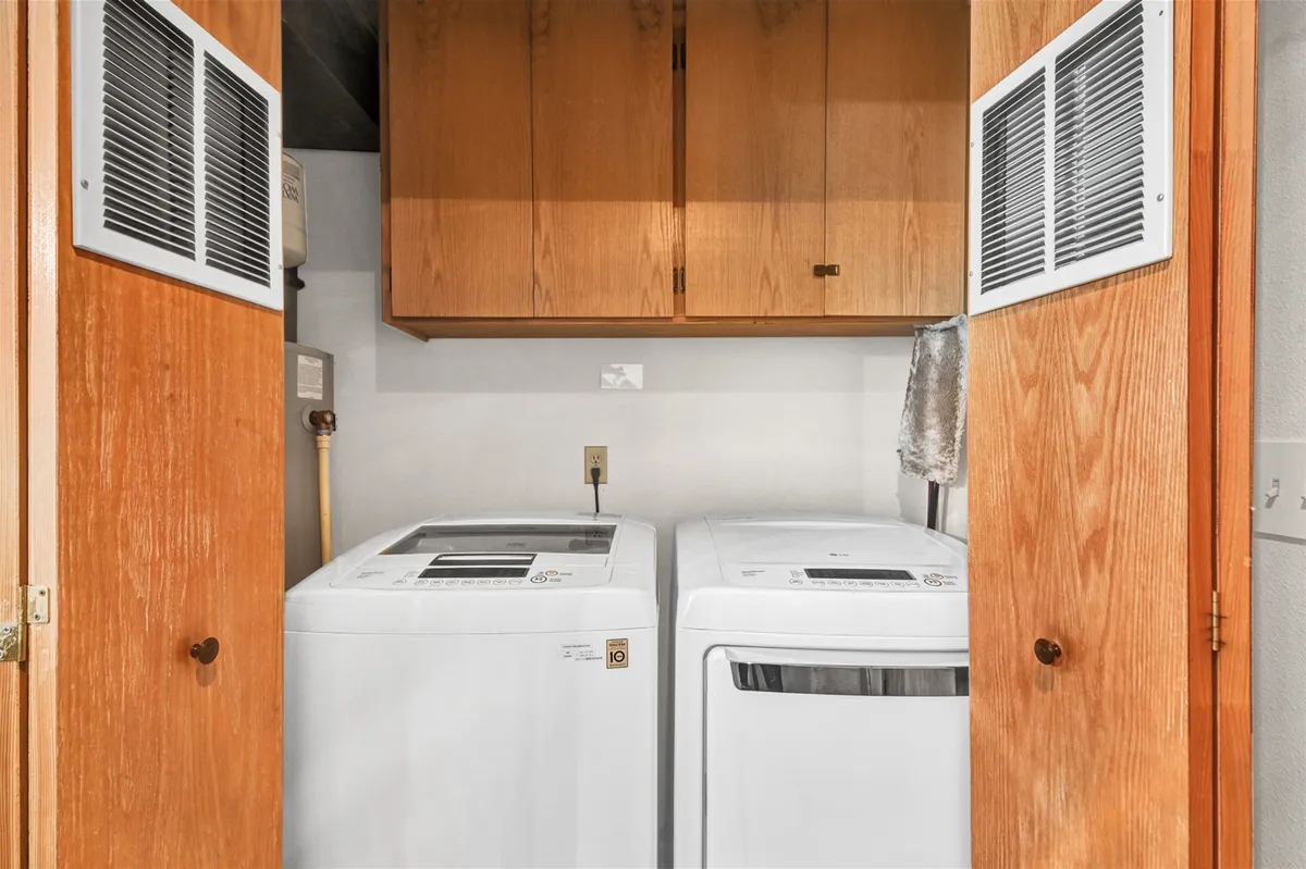 A dedicated laundry area with a washer, dryer, and ample cabinetry for organization. The practical, well-lit space ensures convenience for longer or more comfortable stays.