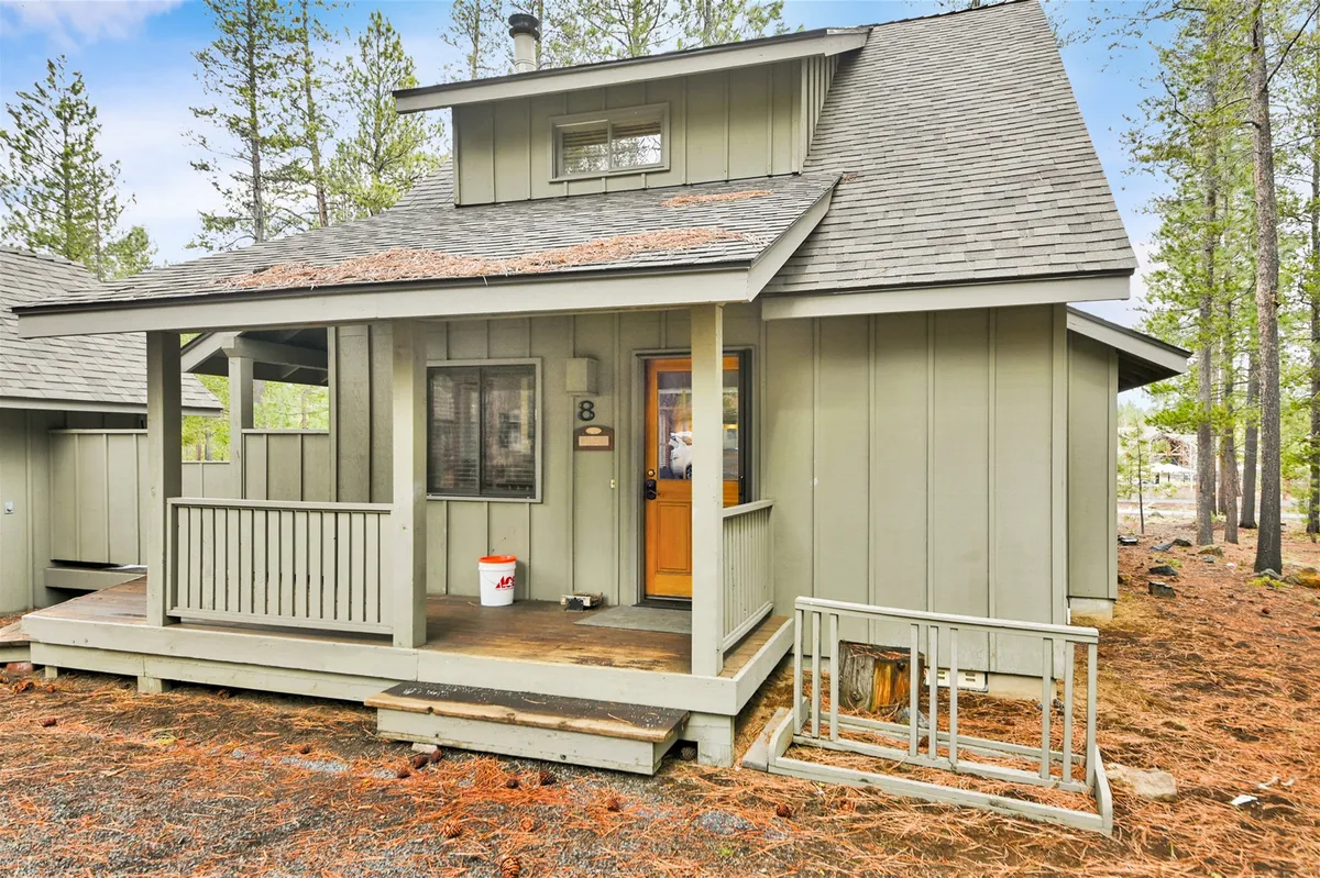 A cozy front porch with a wooden door, windows, and a distinct roofline invites guests to relax and enjoy the outdoors. The image hints at the transition space between indoor comfort and outdoor activity.